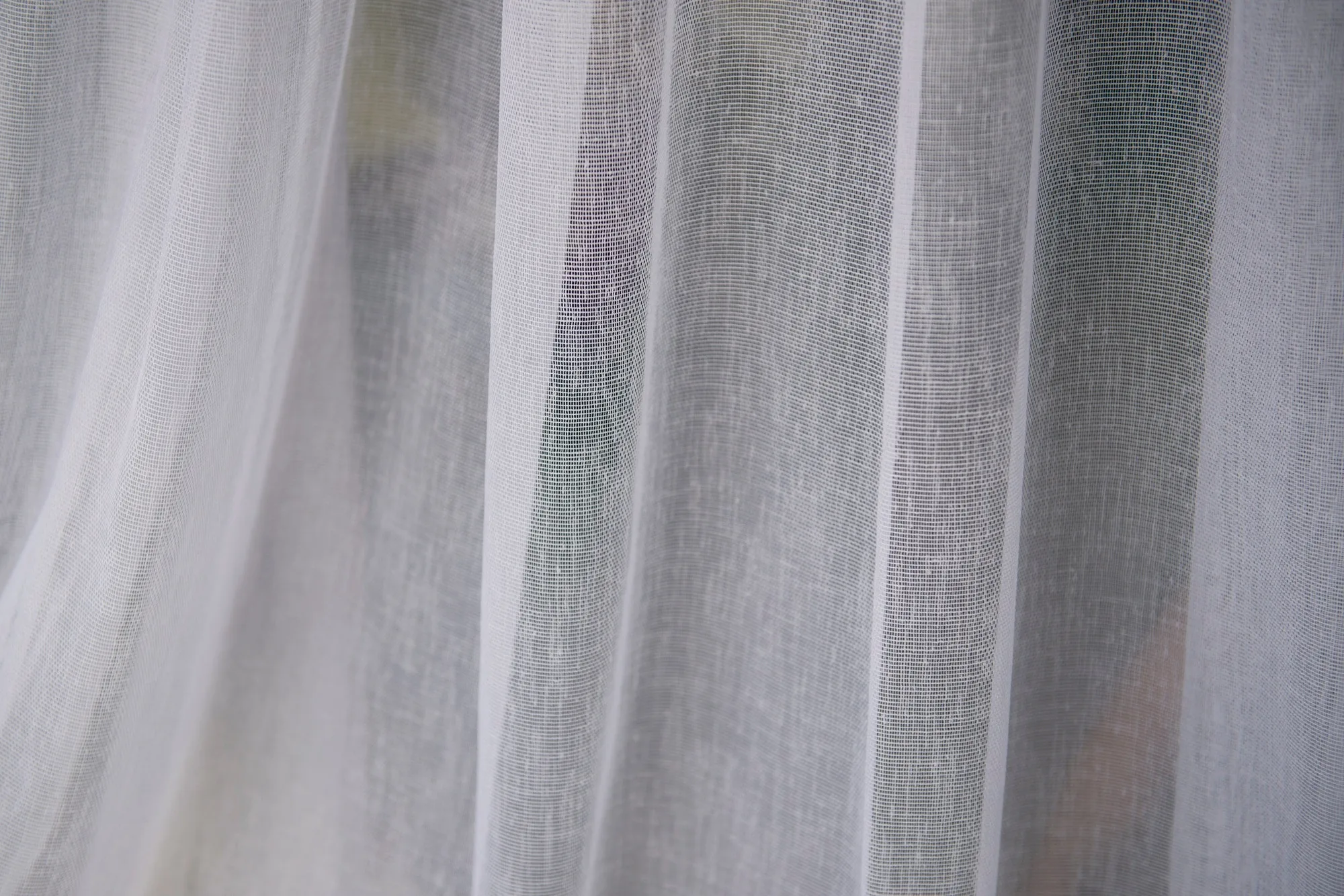 Soft morning light through layered fabric in a quiet room